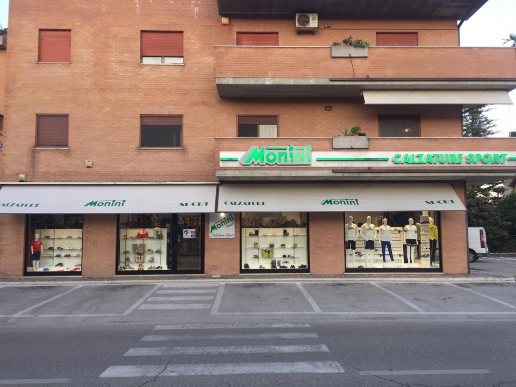 Esterno di Monini Sport: insegna verde e vetrine su Viale della Resistenza